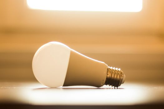 White light bulb lying on a desk, concept for ideas. Sunlight.