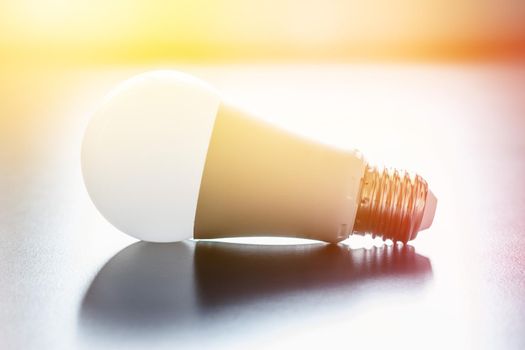 White light bulb lying on a desk, concept for ideas. Sunlight.