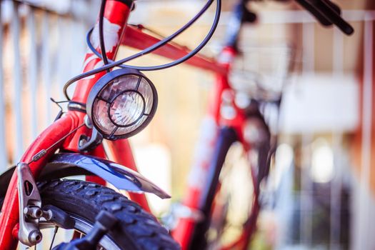 Front picture of a city bike, head lamp and blurry background