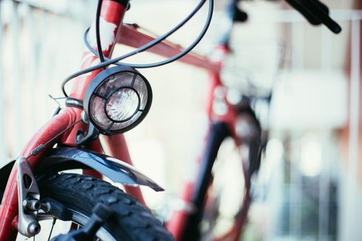 Front picture of a city bike, head lamp and blurry background