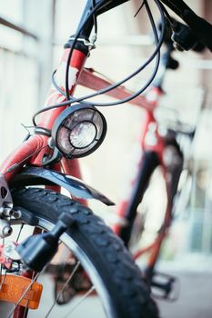 Front picture of a city bike, head lamp and blurry background