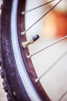 Close up picture of a bike tyre outlet and spokes, blurry background