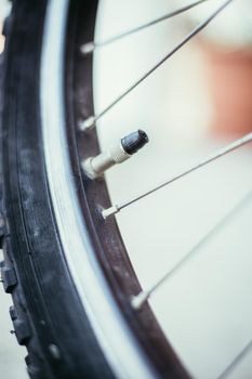 Close up picture of a bike tyre outlet and spokes, blurry background