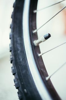 Close up picture of a bike tyre outlet and spokes, blurry background