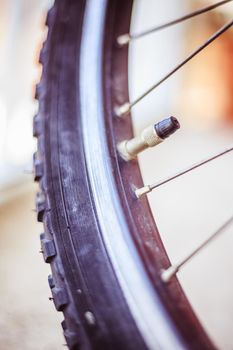 Close up picture of a bike tyre outlet and spokes, blurry background