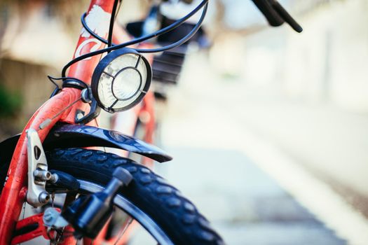 Front picture of a city bike, head lamp and blurry background