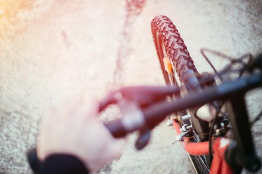Close up picture of a mountain bike tyre, blurry handlebar, summer day