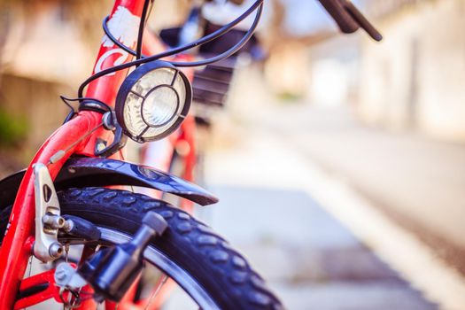 Front picture of a city bike, head lamp and blurry background