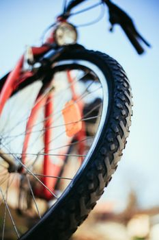 Close up picture of a mountain bike tyre, summer day. Bike in the blurry background.