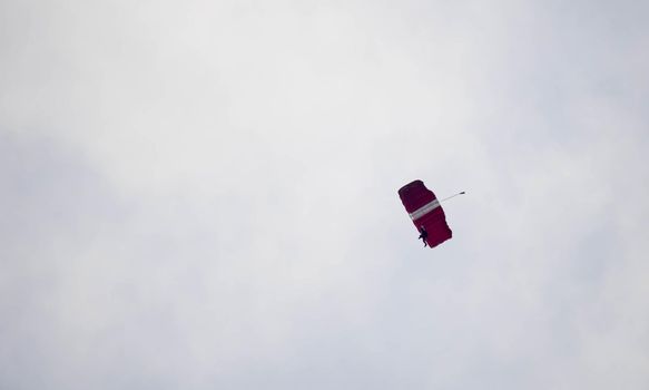 silhouette parachute stunt unfocused and blurry while gliding in the air with blue sky