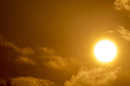 Brilliant orange sunrise over clouds in Asia with bright yellow sun on a cool sunny morning.