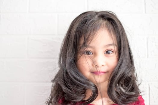 A Fashion model and beauty look. Stylish girl with pretty face on grey background. Hairdresser, skincare, casual style. Beauty and kid fashion with healthy hair. Little girl with long hair.