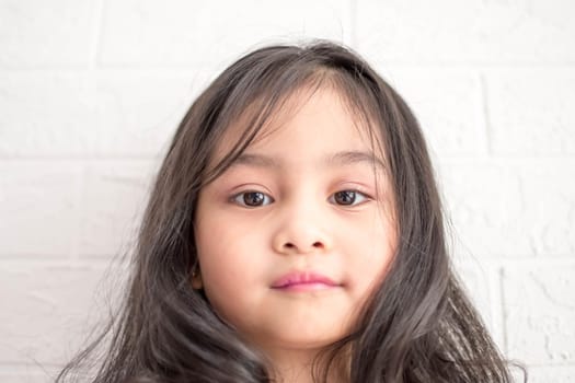 A Fashion model and beauty look. Stylish girl with pretty face on grey background. Hairdresser, skincare, casual style. Beauty and kid fashion with healthy hair. Little girl with long hair.