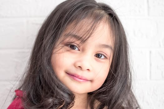 A Fashion model and beauty look. Stylish girl with pretty face on grey background. Hairdresser, skincare, casual style. Beauty and kid fashion with healthy hair. Little girl with long hair.