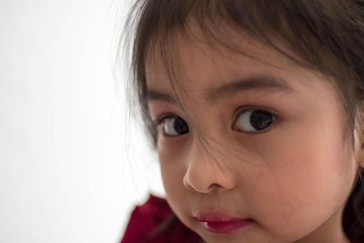 Pretty cute little girl while having a makeup, lipstick and blush on