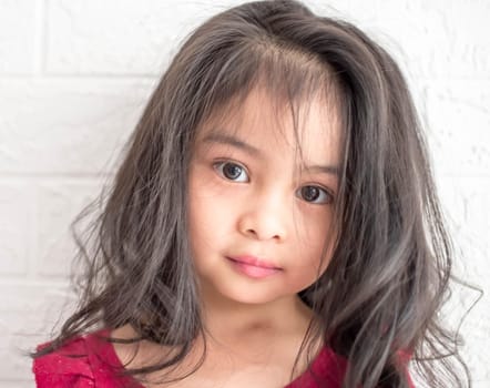 A Fashion model and beauty look. Stylish girl with pretty face on grey background. Hairdresser, skincare, casual style. Beauty and kid fashion with healthy hair. Little girl with long hair.