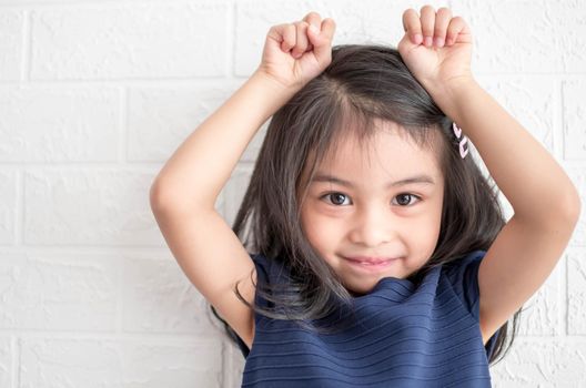 A Fashion model and beauty look. Stylish girl with pretty face on grey background. Hairdresser, skincare, casual style. Beauty and kid fashion with healthy hair. Little girl with long hair.