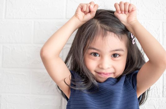 A Fashion model and beauty look. Stylish girl with pretty face on grey background. Hairdresser, skincare, casual style. Beauty and kid fashion with healthy hair. Little girl with long hair.