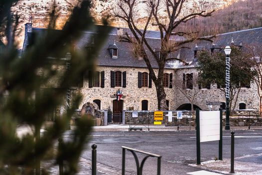 Saint Lary Soulan, France - December 26, 2020: architectural detail of the town hall in the historic city center where tourists walk on a winter evening