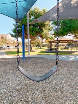 Swing at children playground activities in public park. swing on modern playground. Urban neighborhood childhood concept. 