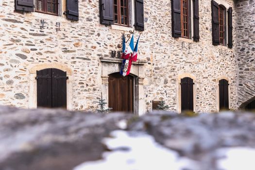 Saint Lary Soulan, France - December 26, 2020: architectural detail of the town hall in the historic city center where tourists walk on a winter evening