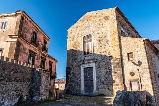 Facade of 'San Pietro' church in Castiglione di Sicilia illuminated by the sun and a blue sky background, Italy