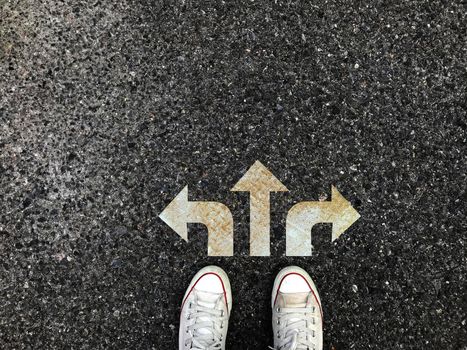 Sneakers shoes with three white arrows print pointing on grunge road , making decision business concept