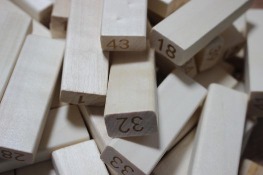 Pile of wooden blocks with engraved letters dispersed on floor. Children toy for building creative works.