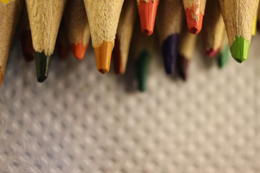 Close-up view of bright colored multicolor pencils on black background