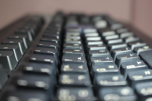 Closeup of laptop computer keyboard black keys with white letters and numbers. Black keys with white characters.