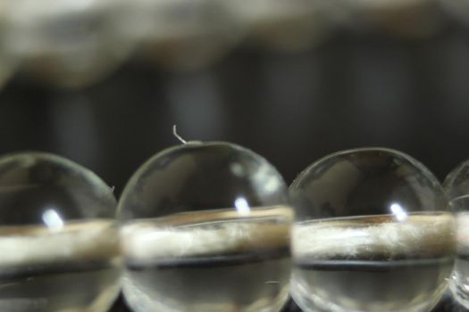 Macro photograph with selective focus of glass shiny prayer beads or rosary with copy space for text. Religion concept of ramadan or Eid for muslims.