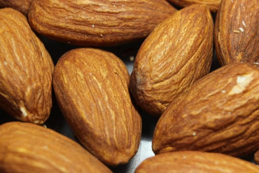 Fruit background of a pile of peeled almond nuts. Composition from almond nuts background - macro photograph of almond nuts