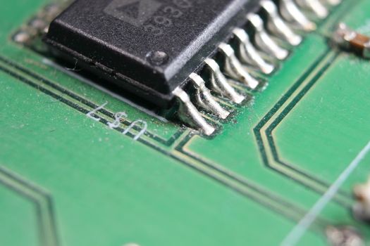 Electronic board with circuit lines and chip. Macro view of green board