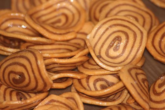 Closeup view with selective focus of a large number of round cookies with coconut filling lines.