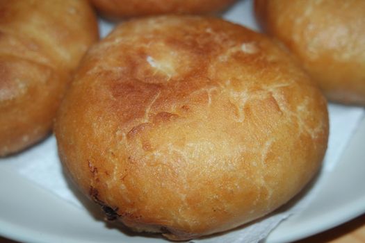 Closeup view of homemade tasty potato bread rolls bun placed over white tissue paper.