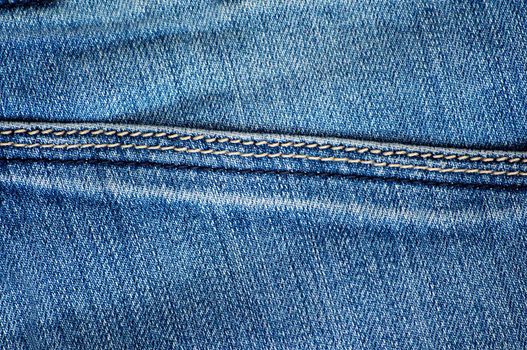 Blue jeans with horizontal stitching close-up. Texture or background