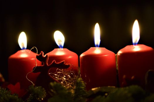close-up of an Advent arrangement with 4 burning candles