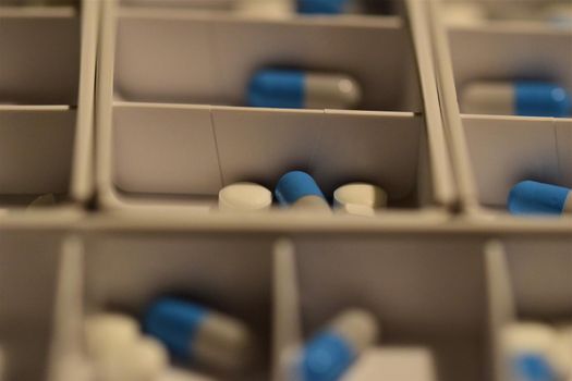 Close-up of different pills prepared in tablets boxes
