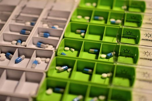 Close-up of different pills prepared in tablets boxes