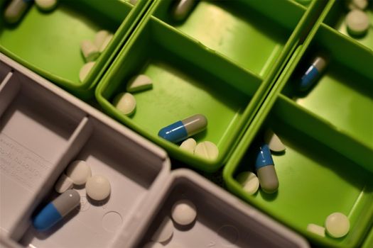 Close-up of different pills prepared in tablets boxes
