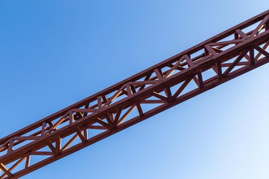 straight red steel welded girder beam on blue sky background