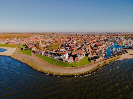 Urk lighthouse with old harbor during sunset, Urk is a small village by the lake Ijsselmeer in the Netherlands Flevoland area. beach and harbor of Urk