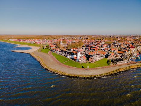 Urk lighthouse with old harbor during sunset, Urk is a small village by the lake Ijsselmeer in the Netherlands Flevoland area. beach and harbor of Urk