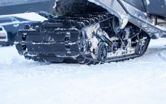 The back of the snowmobile in winter. Riding in the snow on a snowmobile. Rear suspension of a snowmobile