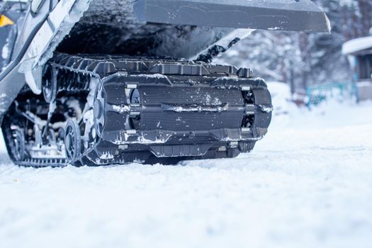 The back of the snowmobile in winter. Riding in the snow on a snowmobile. Rear suspension of a snowmobile