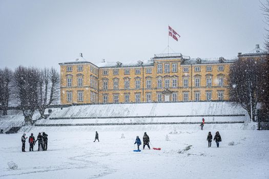 Copenhagen, Denmark - January 06, 2021: People enjoying a snowy winter day in front of the palace in Frederiksberg Gardens