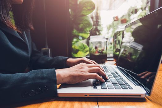 Young businesswoman is working by typing on his computer laptop in a coffee shop