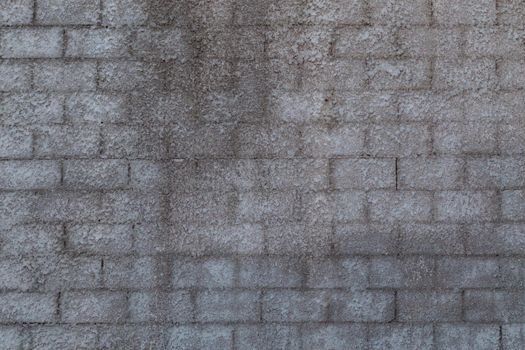 wall of cinder blocks covered with a layer of shagreen concrete plaster, close-up
