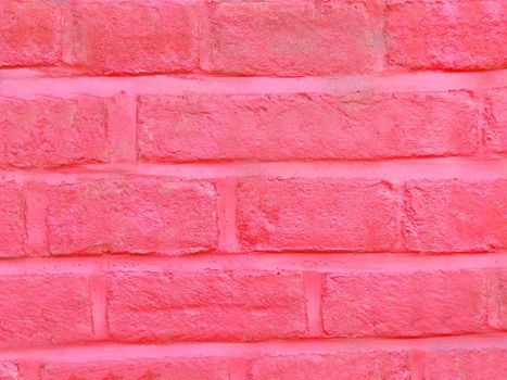 The old brick wall is painted pink in close-up.Texture or background