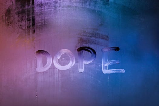 word dope handwritten on night wet window glass surface close-up with selective focus